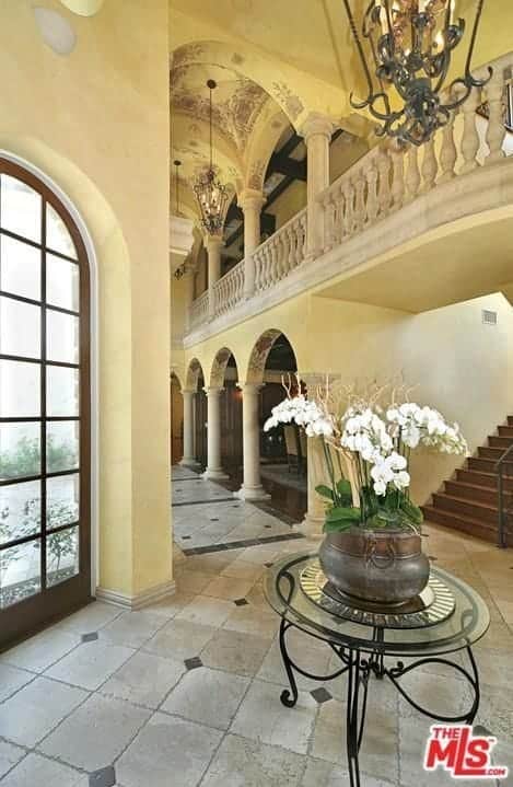 Large Mediterranean foyer featuring tiles flooring and a beautiful ceiling lighted by elegant pendant lights.