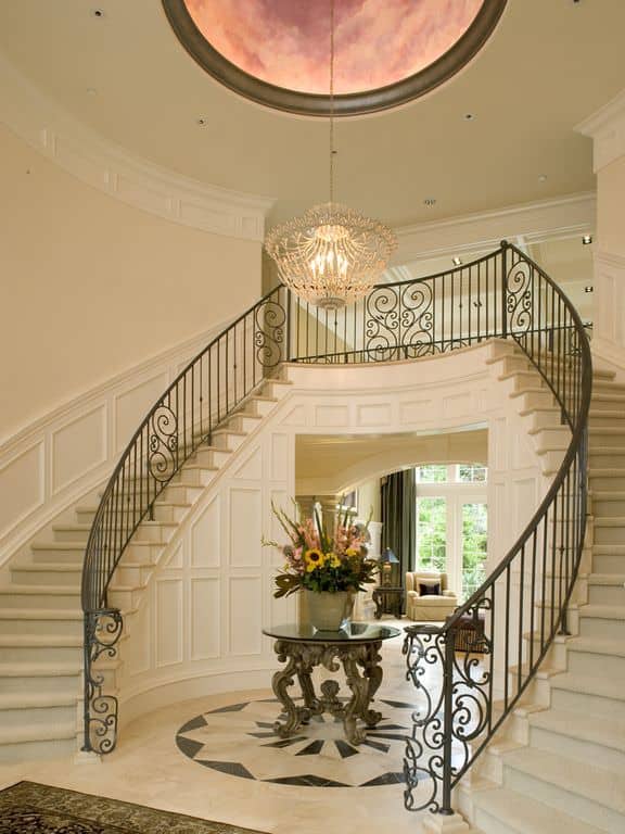 Bright large foyer featuring a lovely flooring and walls, along with elegant staircase and chandelier.