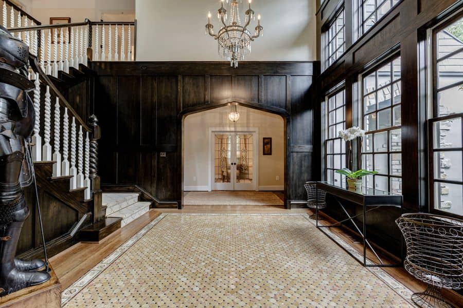 This elegant foyer boasts a vintage soldier armor as a design. The brown finish of the home's details are also jaw-dropping. The chandelier looks perfect together with the foyer.