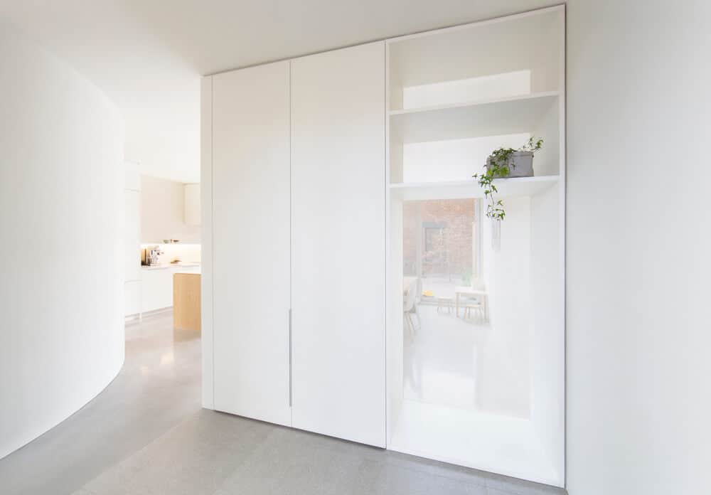 Upon entry of the house's glass doors, you are welcomed by this simple foyer with a large white structure that acts as a divider and even a bike rack on the side.