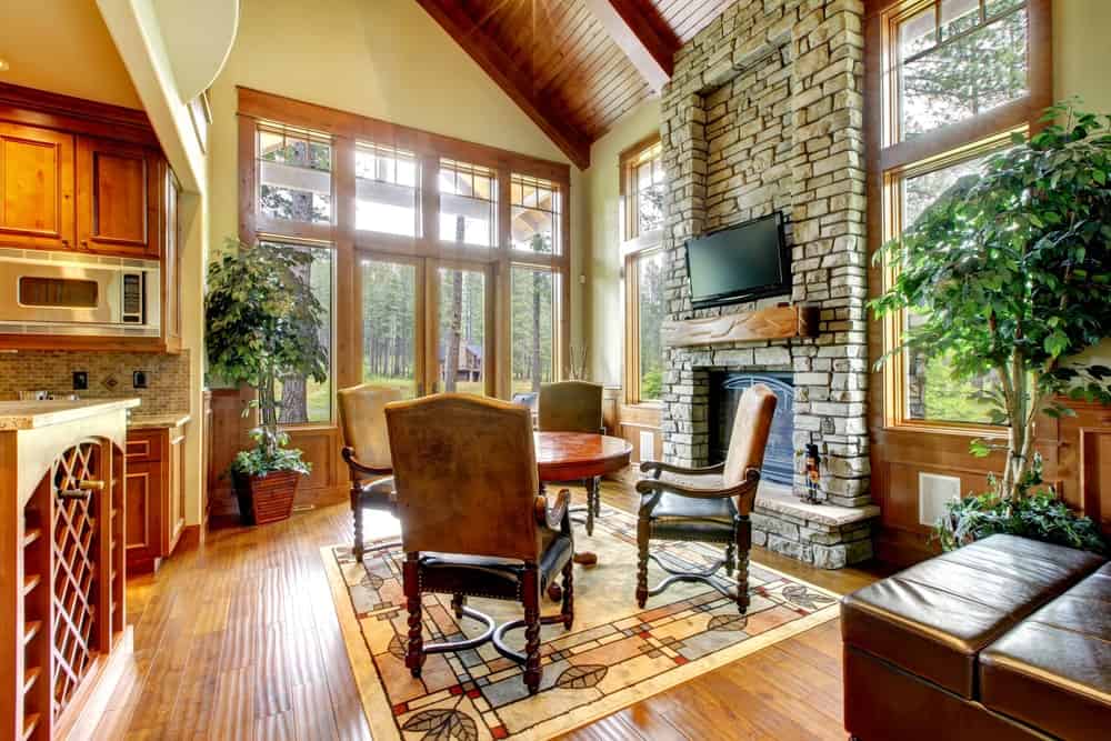 Rustic living room with classy rug and a small round table set near the fireplace.