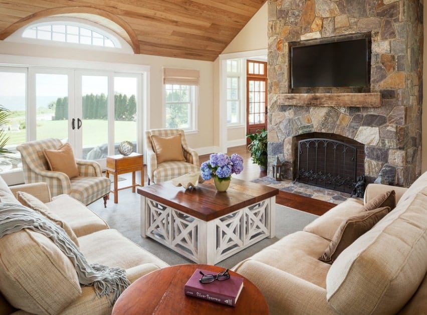 A rustic living room featuring modish and traditional cozy seats near the stylish fireplace.