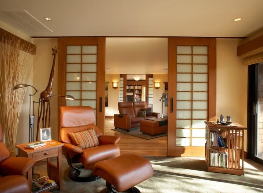 A living room with a rustic shade, featuring comfortable leather seats and romantic warm white lights.