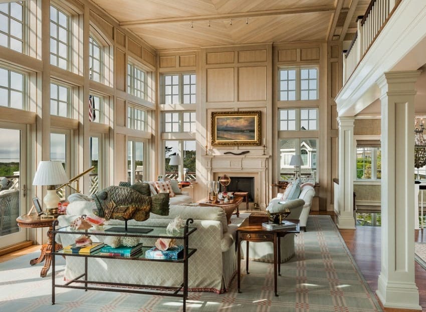 Large living room boasting a high ceiling and stylish beige walls. The seats match the rug set on the hardwood flooring.