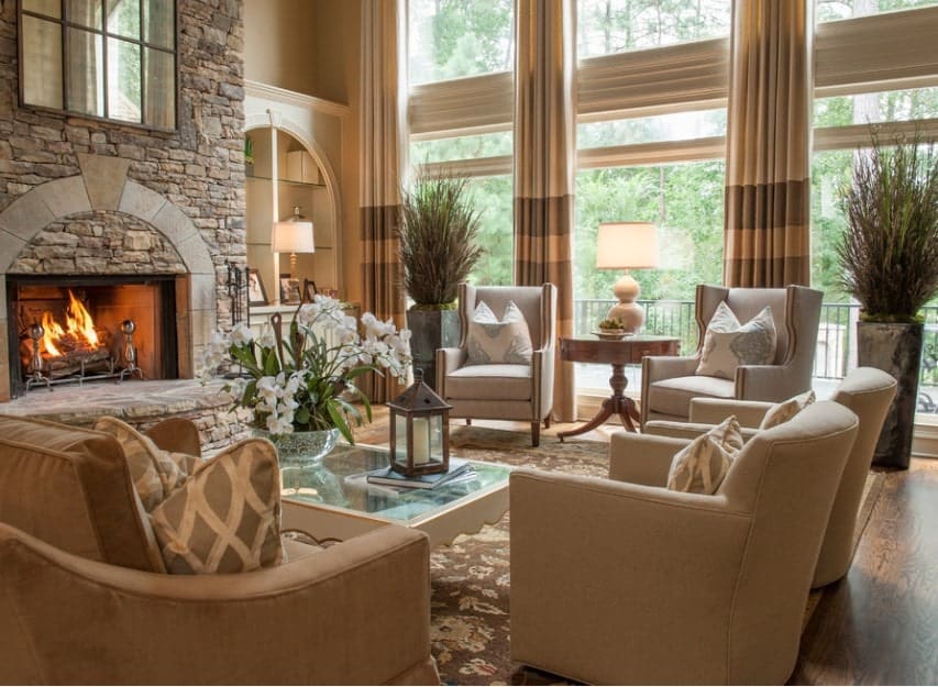 This living room offers a nice set of seats near the fireplace. The rug looks so classy while the tall ceiling adds elegance to the home.