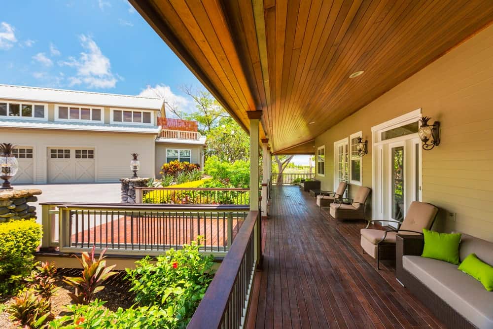 Large deck featuring multiple cozy seats lighted by wall lights.