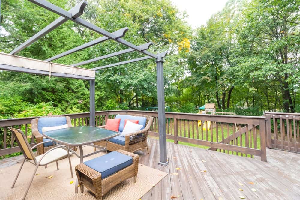 Large deck patio area surrounded by beautiful plants and trees.