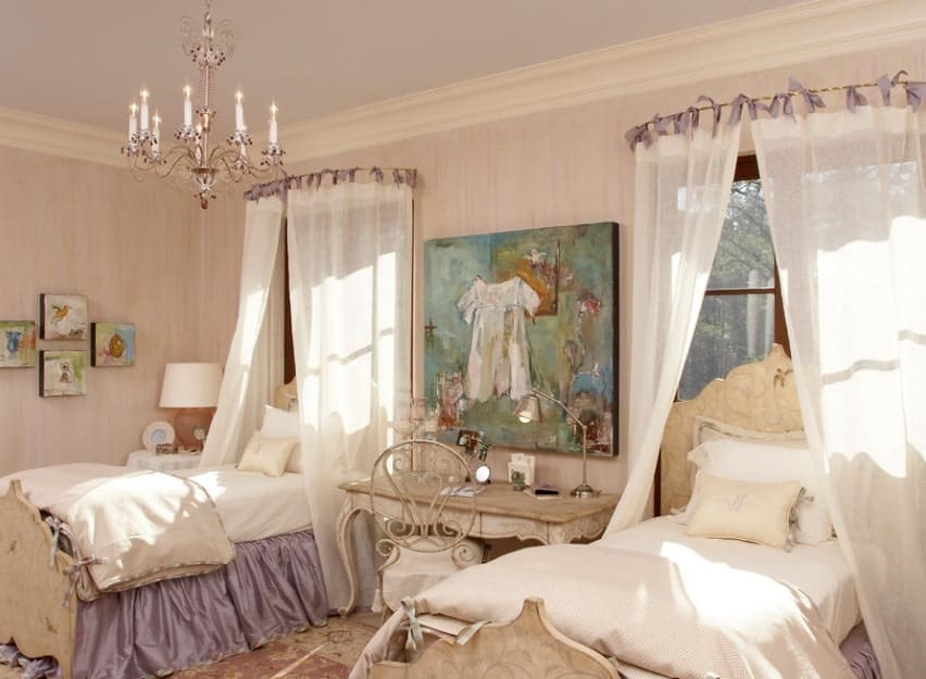 This girls' bedroom offers a twin bed with a lovely desk in the middle, along with artistic wall decors. The chandelier looks absolutely glamorous.