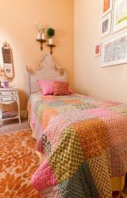 This girl's bedroom boasts carpet flooring topped by a classy rug, surrounded by beige walls.