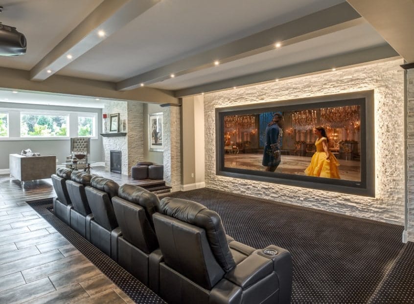 This home features a media room with black leather theater seating set on the stylish carpet flooring.