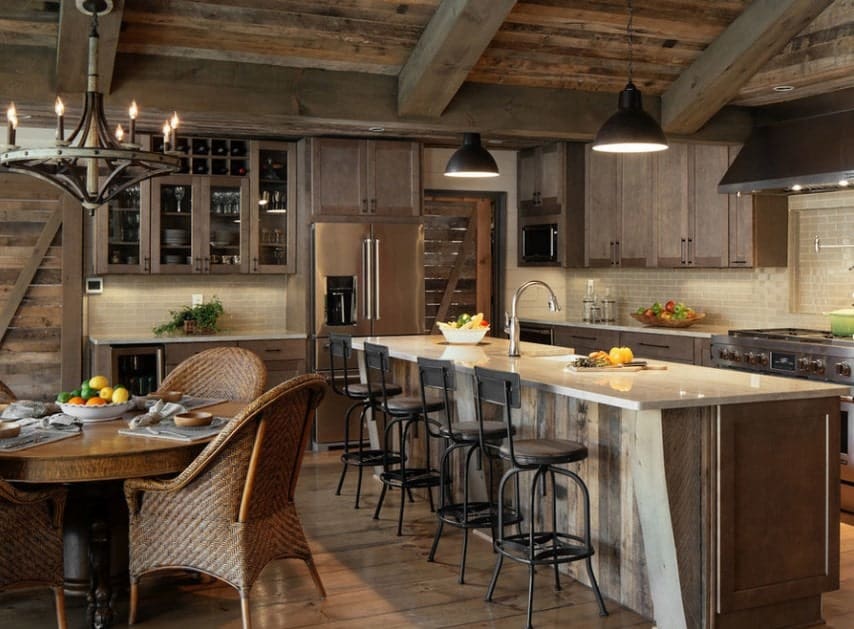 Rustic kitchen with a large center island with a smooth countertop lighted by pendant lights.
