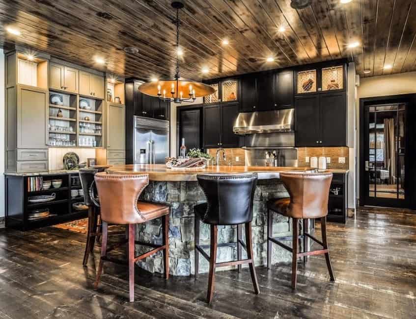 Stunning rustic kitchen featuring a stunning ceiling lighted by recessed lights and candlelight chandelier. The flooring and center island look so stylish as well.