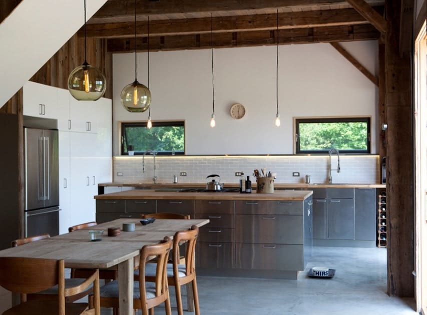 This kitchen boasts wooden countertops on both counters and center island. The rustic ceiling looks magnificent while the lighting looks perfect with the kitchen's style as well.