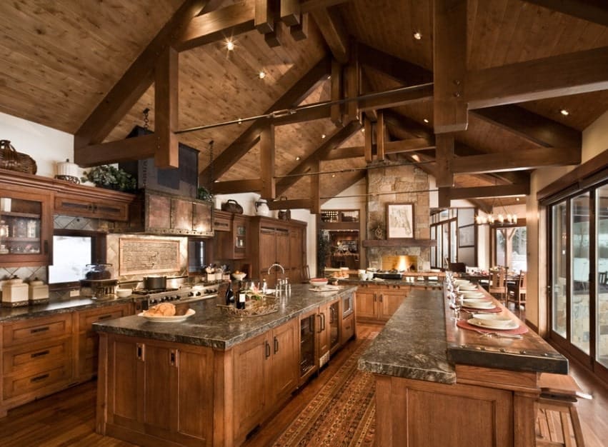 Large rustic kitchen featuring a large center island with granite countertop. There's a long breakfast bar too.