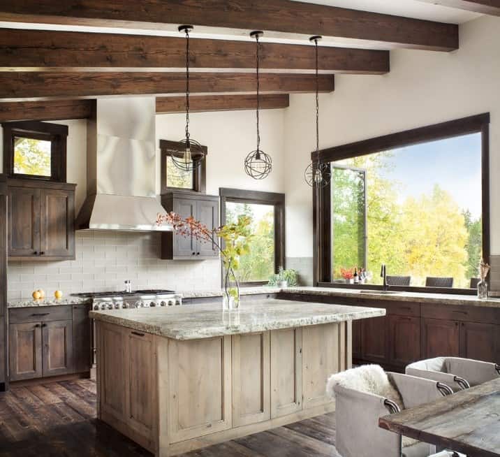 Vintage style rustic kitchen with a large center island lighted by pendant lights.