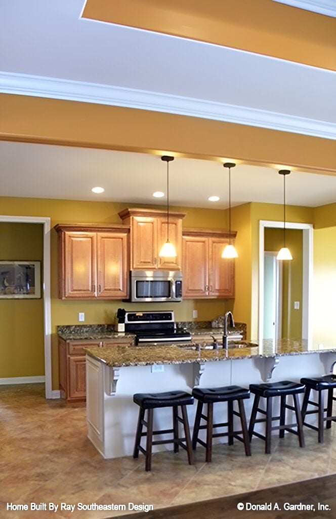 Recessed ceiling lights and glass dome pendants add a cozy feel to the kitchen.