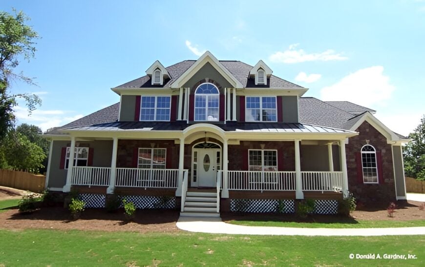 Front exterior view with a wide front porch topped with charming dormers.