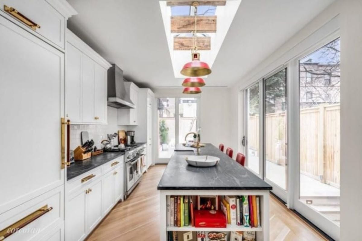 This single wall kitchen boasts a very stylish center island and breakfast bar combo lighted by pendant lights and skylight.