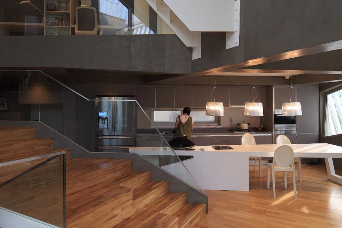 A stunning home with a jaw-dropping kitchen set up. The breakfast bar counter set on the hardwood flooring looks so enchanting together with its pendant lighting.