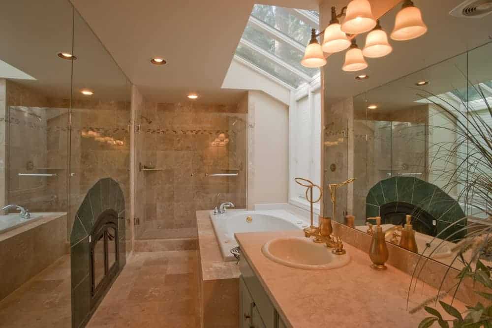 Primary bathroom with beige tiles walls and floors, and a large bathtub, along with a walk-in shower room.