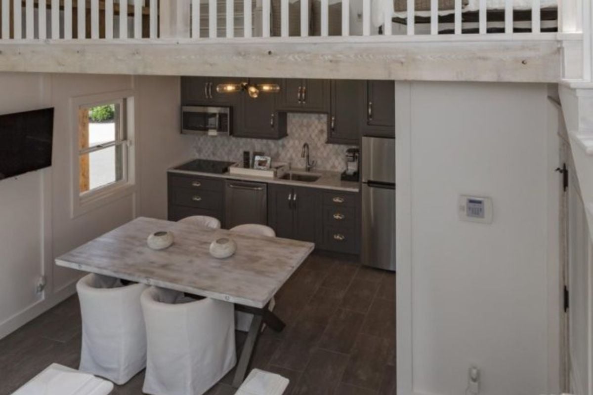 This home boasts a small kitchen set on the hardwood flooring. The kitchen counters and cabinetry look elegant together with the ceiling lighting.