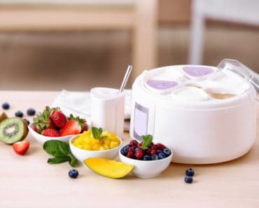 Ingredients and a yogurt maker on a table