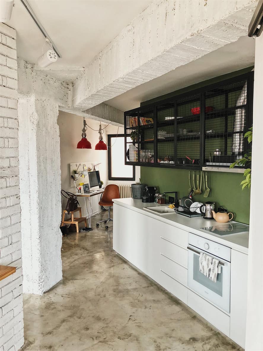 This is a loft apartment with a single line kitchen featuring a solid green wall which works pretty well. Again, all the white offset the green nicely.