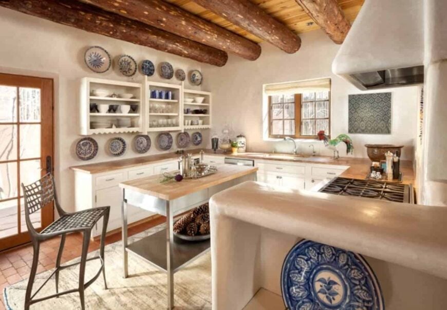 Southwestern kitchen features white cabinetry topped with wood counter and decorated with ceramic dinnerware.