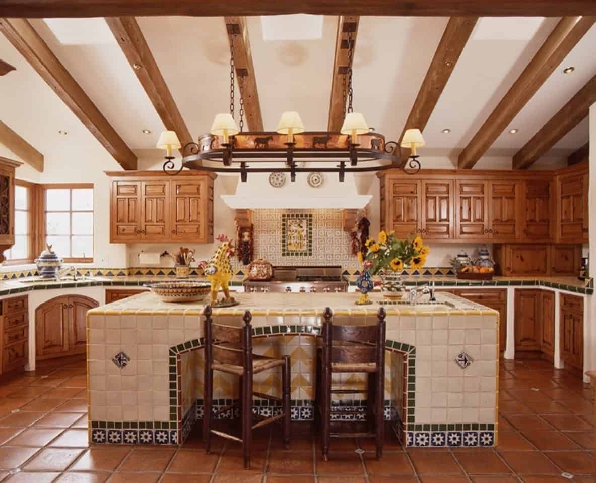 Southwestern kitchen with a Mexican touch. Wooden chairs sit on a tiled breakfast island over a slate flooring.