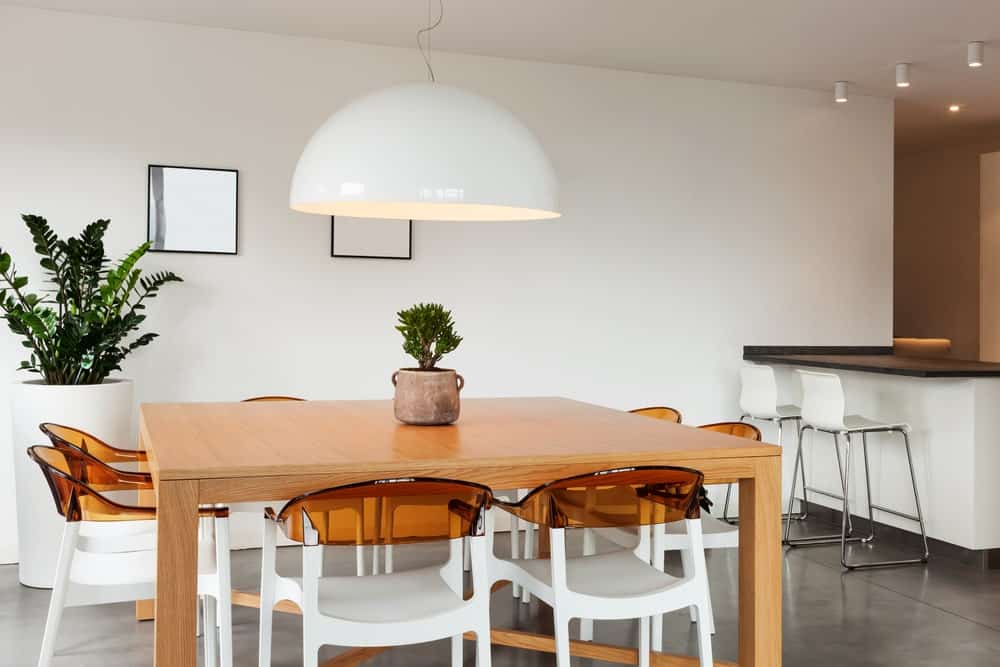 A close up look at this dining table set wit charming modern seats and a large square dining table.