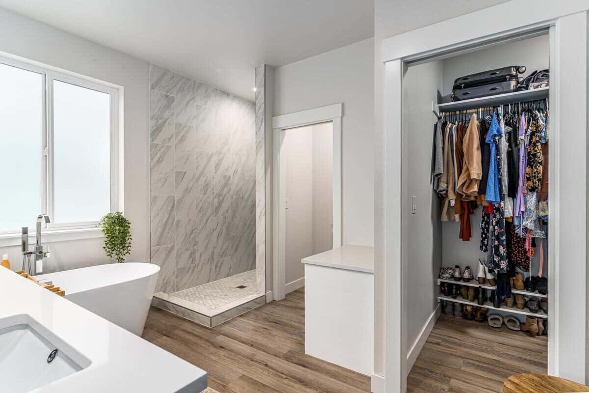 Primary bathroom with a walk-in closet, a makeup counter, toilet room, and an open shower area.