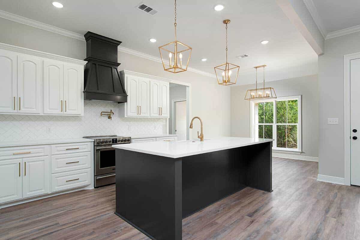 The kitchen features white cabinets beautifully contrasted by a black range hood and island.