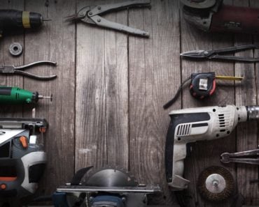 A set of hand tools on a black wooden table.