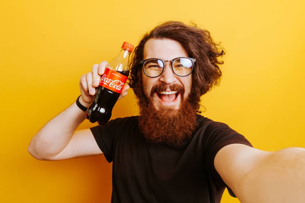 Man holding a bottle of Coca Cola