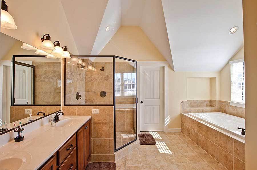 The primary bathroom offers a drop-in bathtub, a walk-in shower, and a dual sink vanity paired with a frameless mirror.