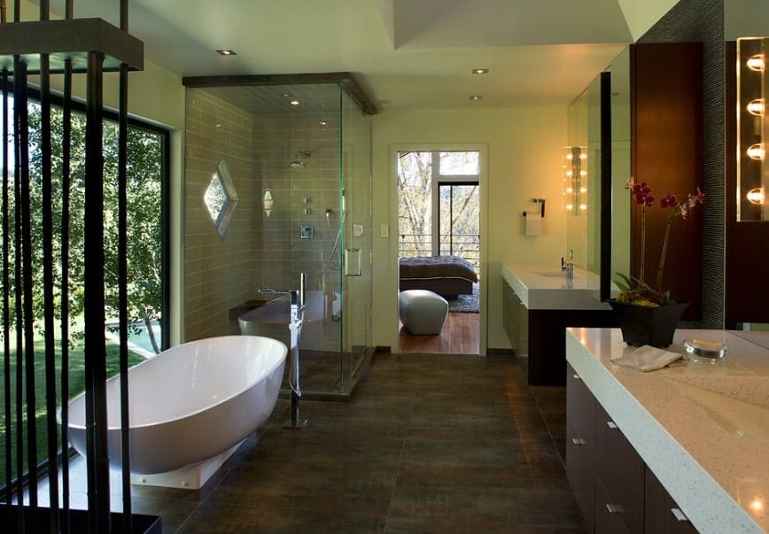 Green primary bathroom featuring a freestanding tub, a walk-in shower area and two sink counters.