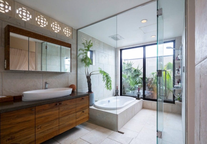 Asian-style primary bathroom featuring a walk-in shower room and tub. The room also offers a sink counter with a large vessel sink.