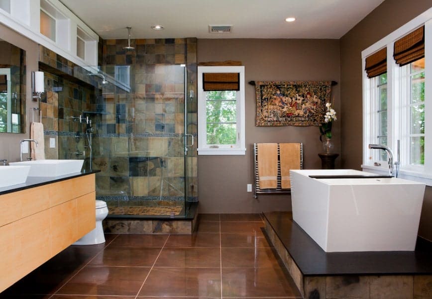 This Asian-style primary bathroom offers a walk-in shower, a freestanding tub on a nice platform and a sink counter featuring two vessel sinks.