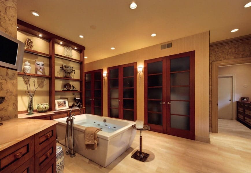 Large Asian-style primary bathroom featuring a freestanding soaking tub along with a shower room. The area has built-in shelves and cabinetry.