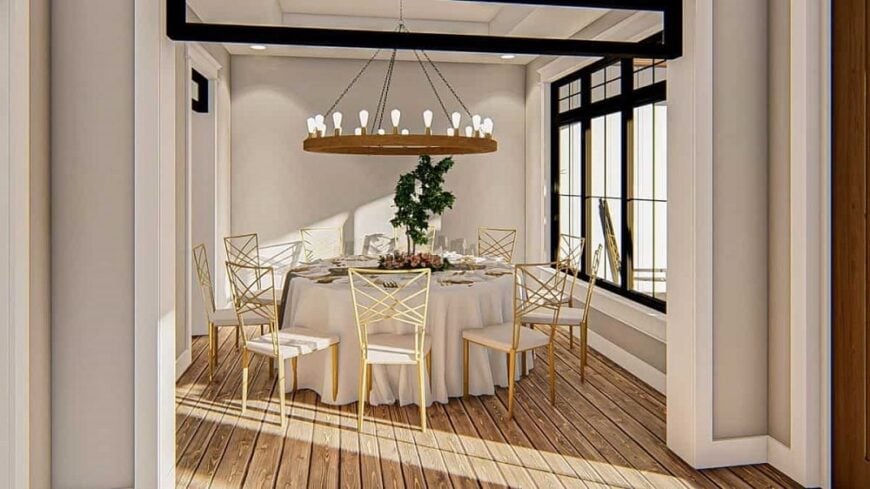 This is the formal dining room that has a large round dining table topped with a round chandelier and surrounded by wooden chairs brightened by the natural lighting of the window.
