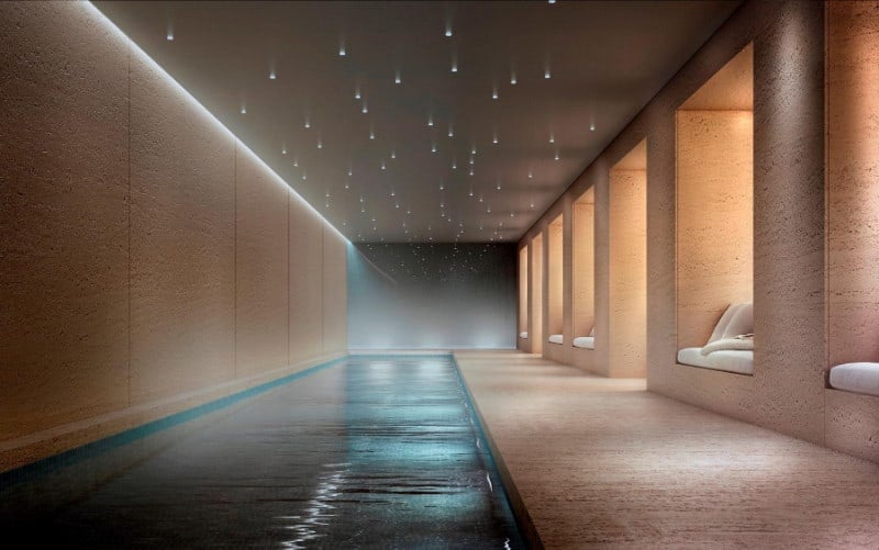 A large indoor swimming pool that is lighted by jaw-dropping ceiling lights.