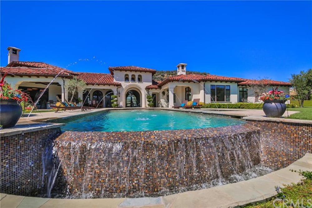 A close up look at this amazing swimming pool design set on the home's outdoor area with a garden and a patio.