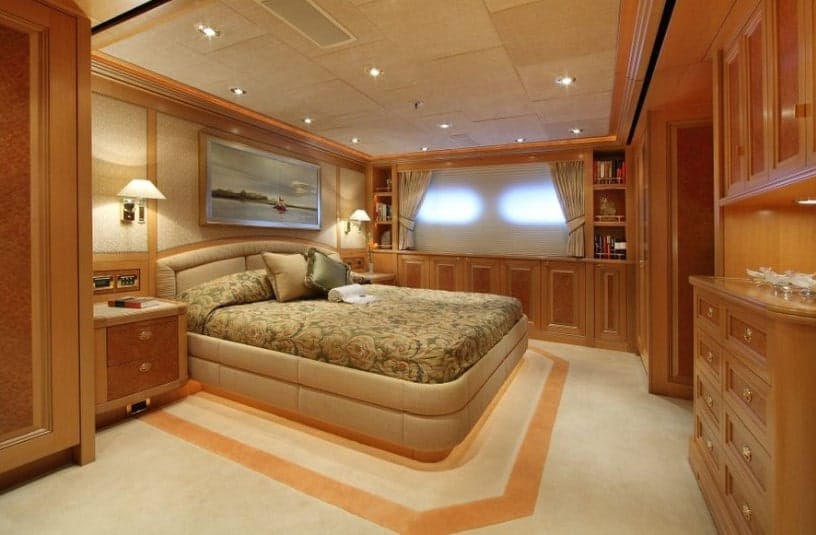 A primary bedroom boasting decorated carpet flooring and brown walls. The room has a large and extremely comfy bed along with cabinetry and built-in shelving.