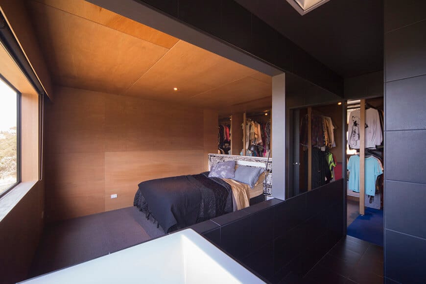 A custom-made primary bedroom featuring a cozy bed set, multiple reach-in closets and a personal bathroom.