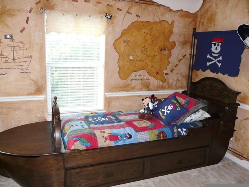 Boys bedroom boasting a pirate boat-inspired bed set surrounded by map-designed walls that look absolutely stylish.
