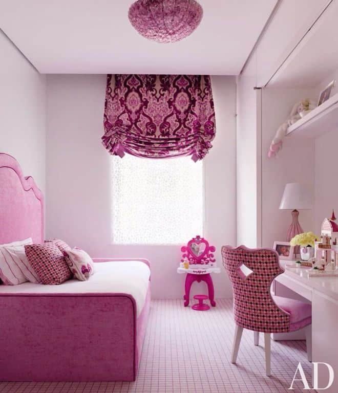 Girls bedroom featuring a lovely pink large custom bed along with a study desk featuring a gorgeous pink chair. The room has a pink ceiling light and a pink window curtain.