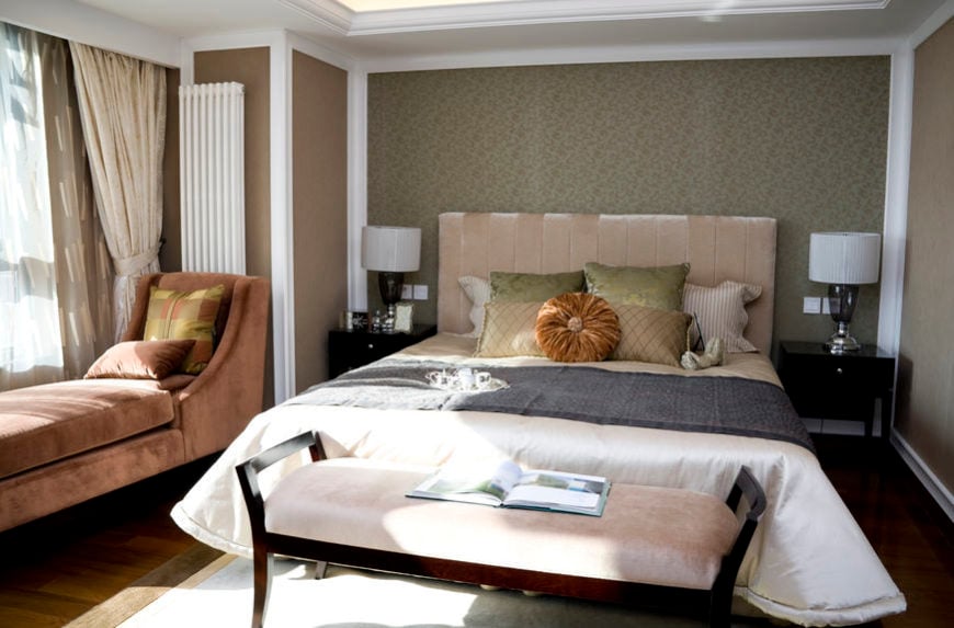 A closer look at this primary bedroom's bed setup with table lamps on both sides. The room has brown walls and a custom ceiling, along with hardwood flooring.