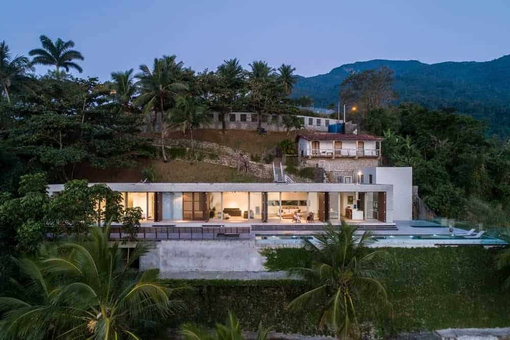 Aerial view of the house with a fancy exterior surrounded by an amazing natural landscape.