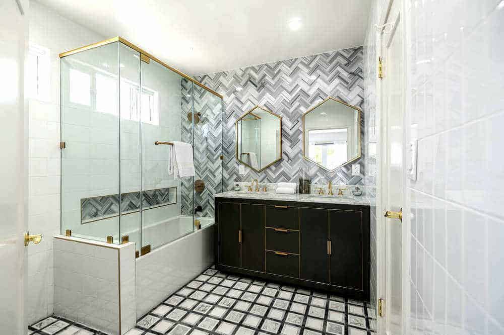 Here’s a look at the bedroom suite’s personal bathroom, featuring stylish walls and floors, along with a nice sink counter and a shower and bathtub combo