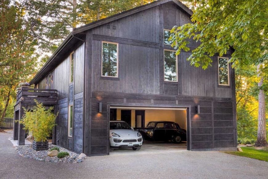 Side exterior view shows the three-car garage lit by cylindrical sconces.